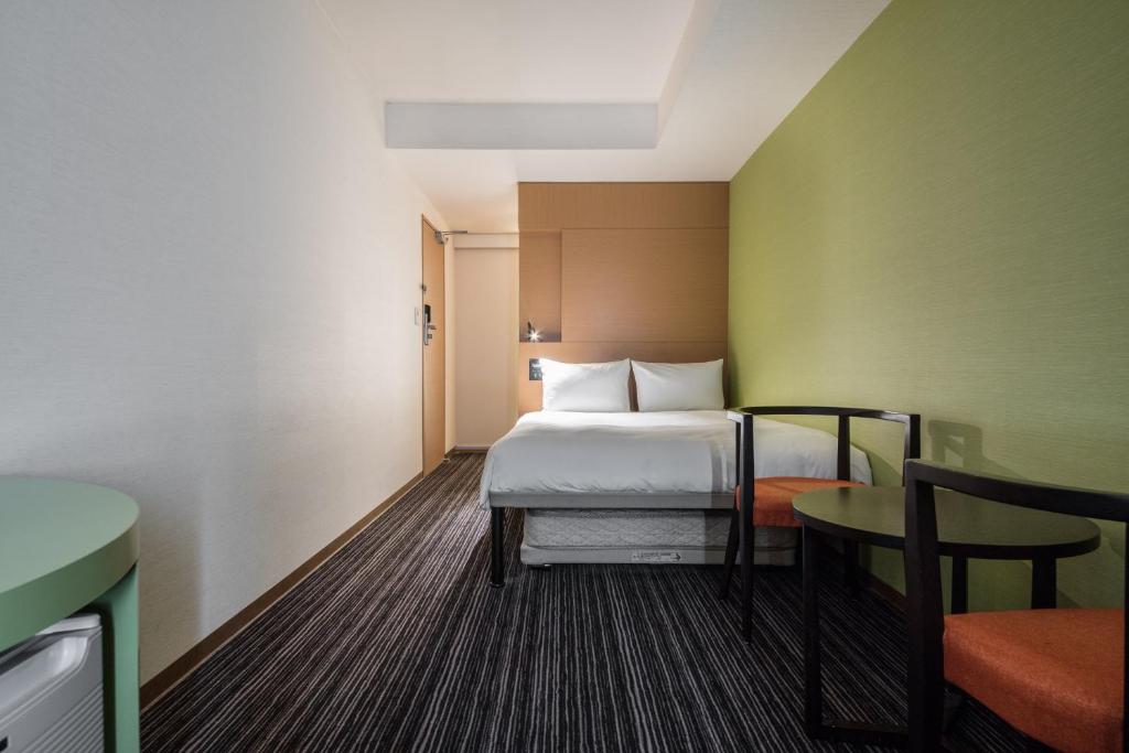 a hotel room with a bed and a table at the b ikebukuro in Tokyo