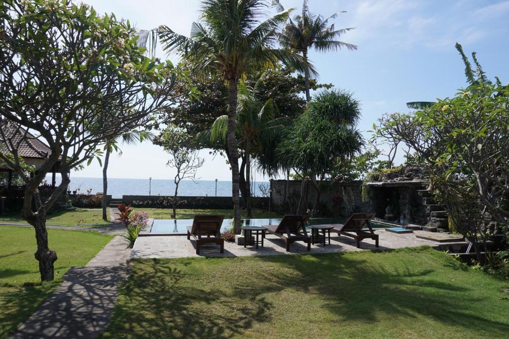 un parque con bancos y vistas al océano en Pondok Bali Sea View Bungalow en Lovina