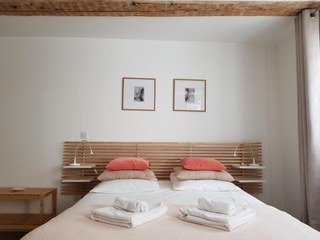 une chambre avec deux lits avec des serviettes dessus dans l'établissement Studio Maison Verte Colmar Centre, à Colmar
