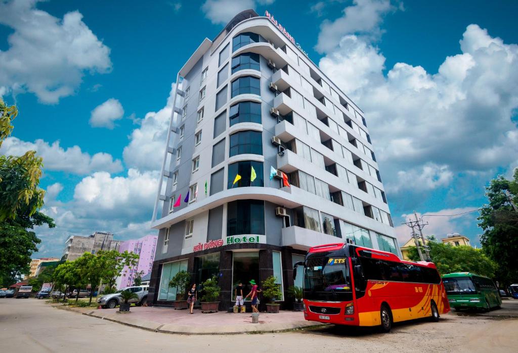 um autocarro vermelho estacionado em frente a um edifício em Hai Dang Hotel em Cửa Lò