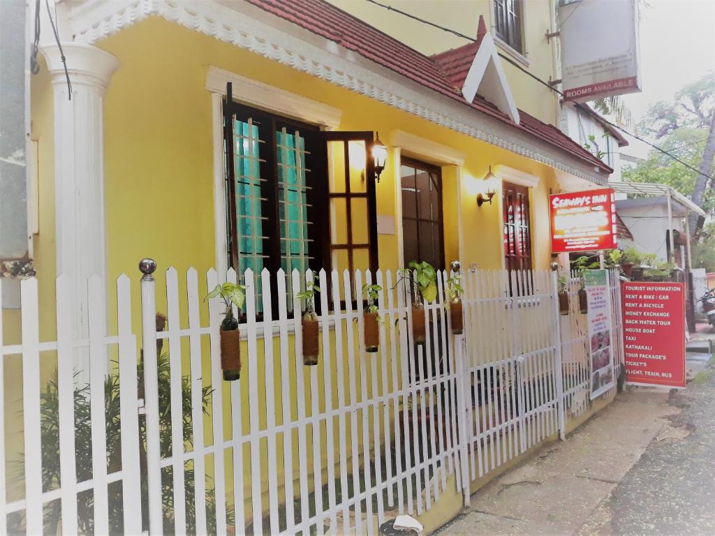 a yellow house with a white picket fence at seaway's inn in Cochin
