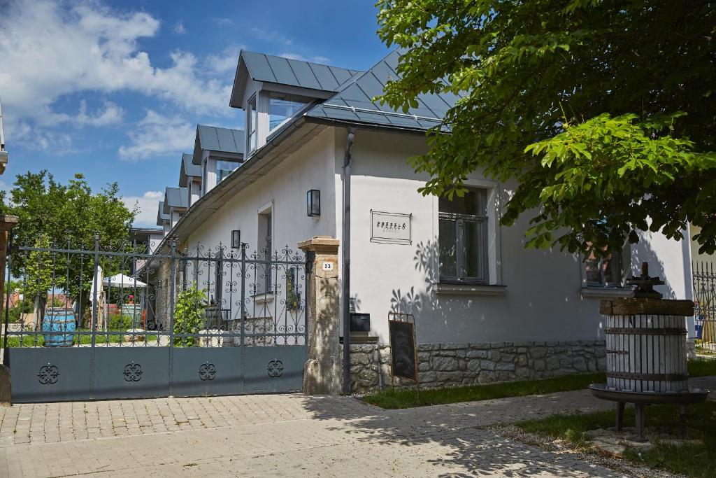 a white house with a gate and a fence at Préselő Pincészet és Vendégház in Erdőbénye