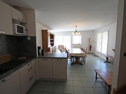a kitchen with white cabinets and a table in it at Gîte de la Grande Fontaine in Isches