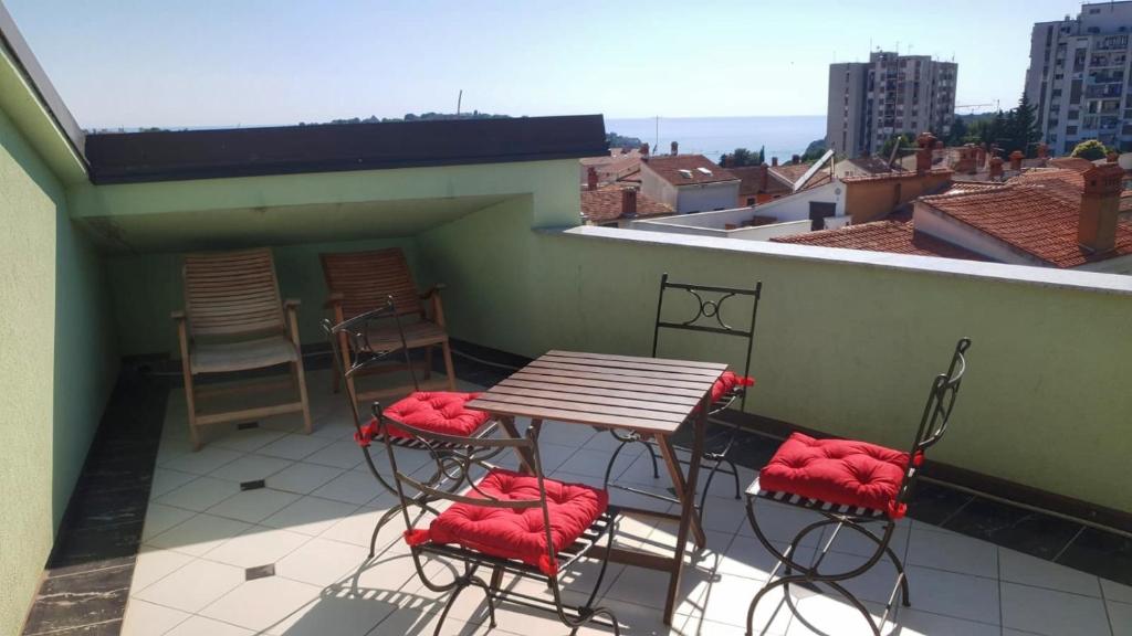 a balcony with a table and chairs on a roof at Apartments Paradiso in Pula