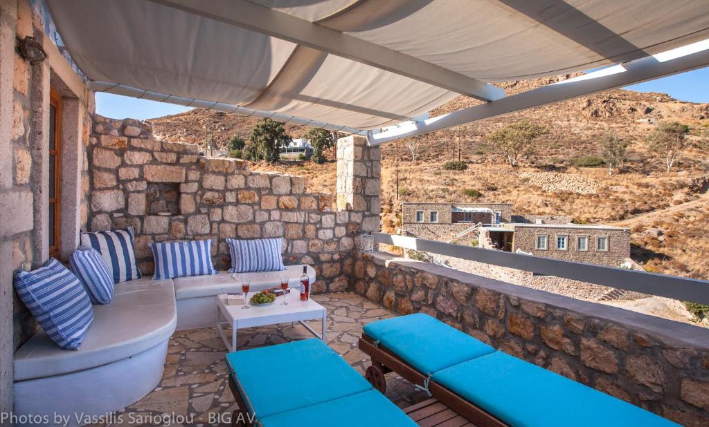 a patio with blue pillows and a table and chairs at Theologos Houses in Grikos