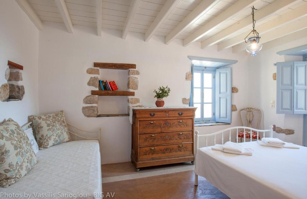 a bedroom with a bed and a dresser in a room at Theologos Houses in Grikos