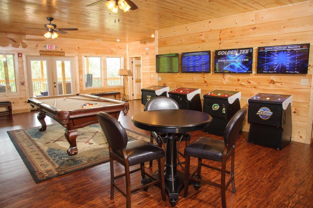 ein Spielezimmer mit einem Billardtisch und mehreren Maschinen in der Unterkunft Foxwood Mansion Cabin in Pittman Center