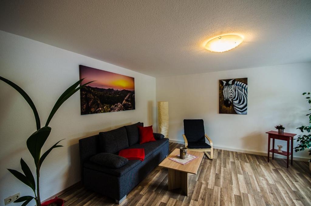 a living room with a blue couch and a table at Ferienwohnung an der Habe in Bad Schandau