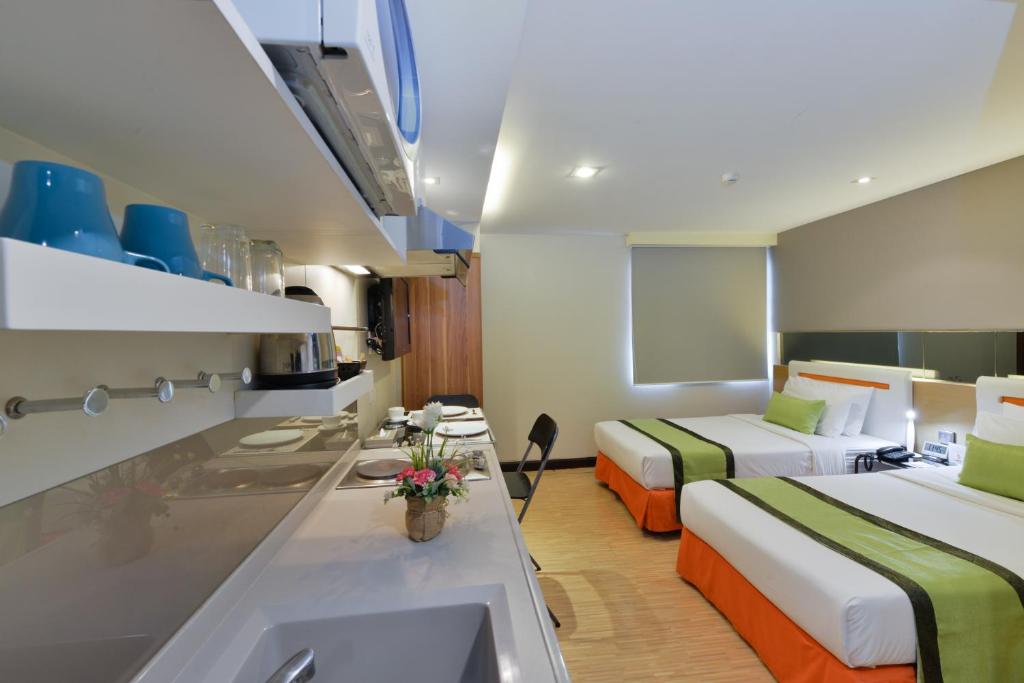 Habitación de hotel con 2 camas y lavamanos en Arawana Express Phromphong, en Bangkok