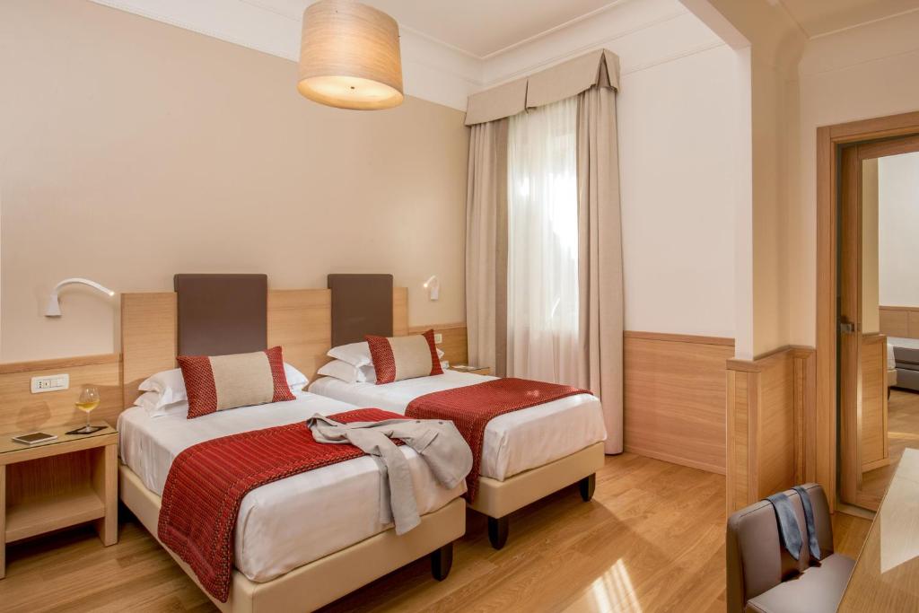 Postel nebo postele na pokoji v ubytování Hotel Nord Nuova Roma