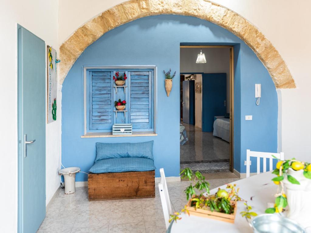 a room with a blue wall and a window at L' Arena Suite - Sicilian style 140 mq flat with balcony and Arena seeview in Castellammare del Golfo