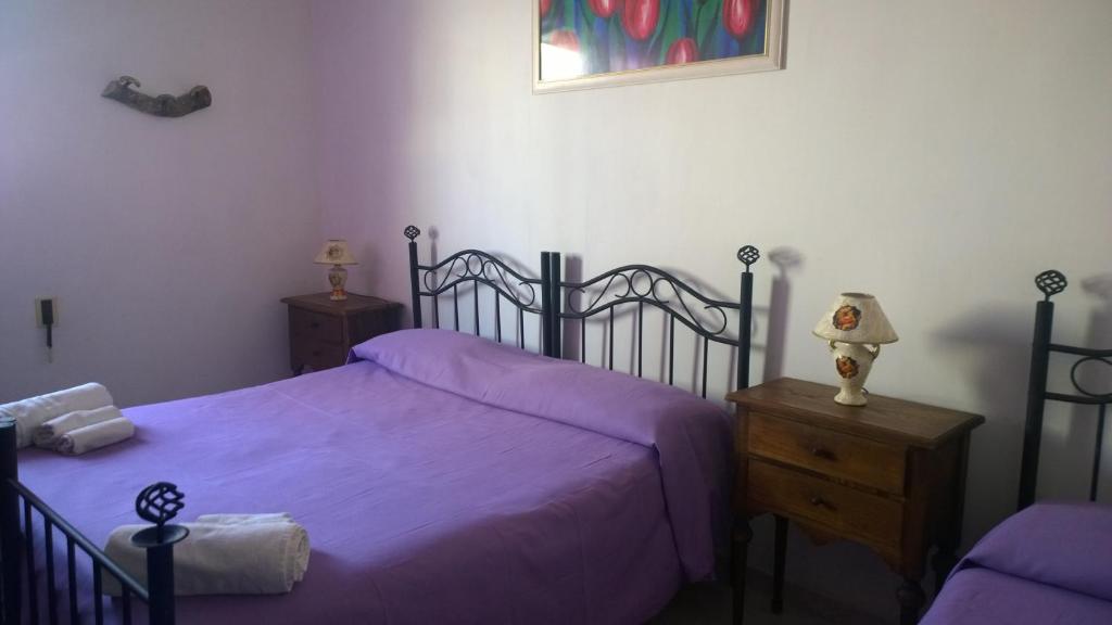 1 dormitorio con 1 cama con sábanas moradas y vestidor en B&B Salento Vacanze, en Maglie