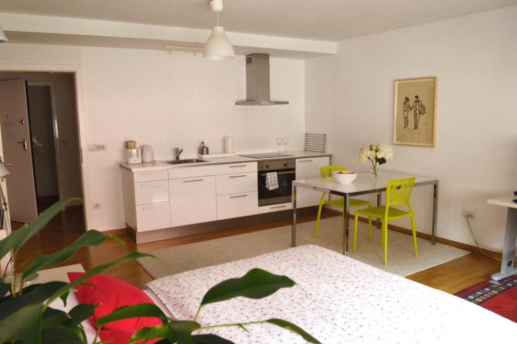 a kitchen with a table and yellow chairs in a room at Studio in Ljubljana Center in Ljubljana