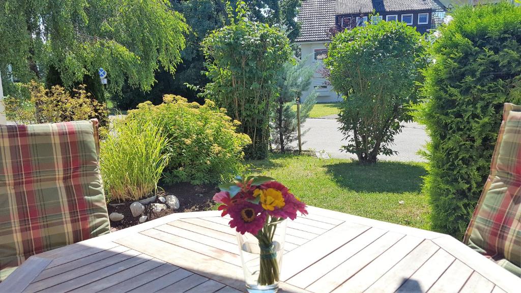 a vase of flowers sitting on a wooden table at Ferienwohnung am Bodensee in Nonnenhorn