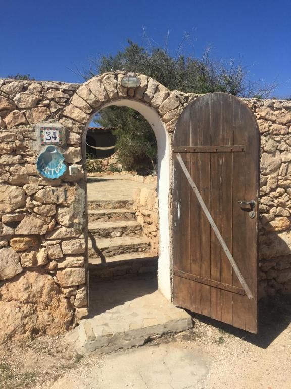 un ingresso a un muro di pietra con porta in legno di Casa Tortuca a Lampedusa