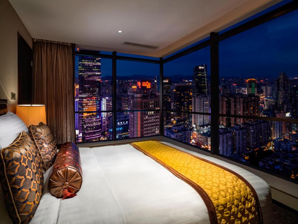 a bedroom with a large window with a city skyline at Oakwood Premier Guangzhou in Guangzhou