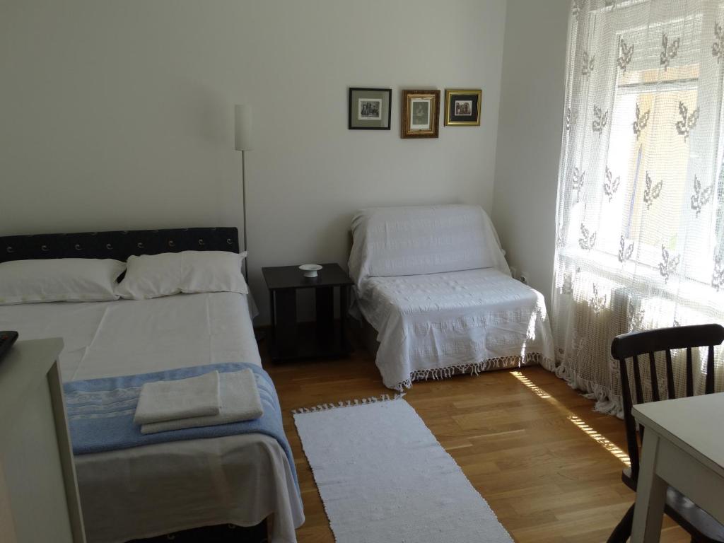 ein kleines Zimmer mit 2 Betten und einem Fenster in der Unterkunft Marijana - Center in Novi Sad