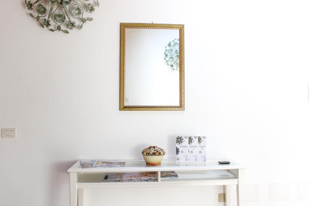 a white console table with a mirror on the wall at Sant'Agata in Ravenna
