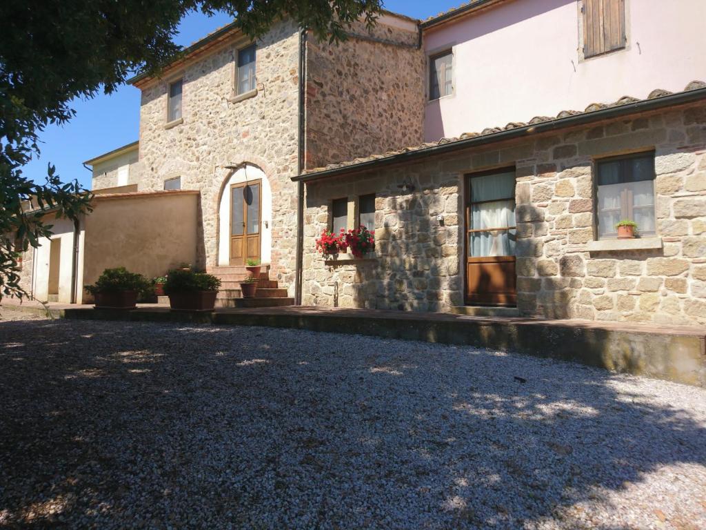 una antigua casa de piedra con una gran entrada en Agriturismo Il Giovannello, en Roccastrada