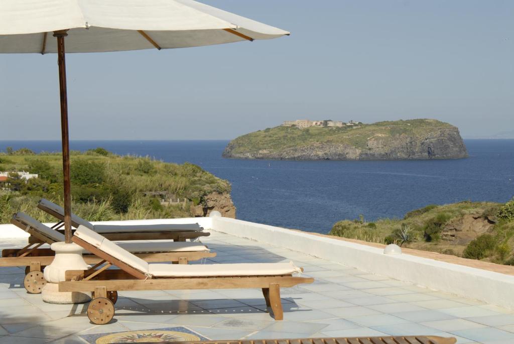 文托泰內的住宿－Hotel Agave e Ginestra，一排带遮阳伞的躺椅和大海