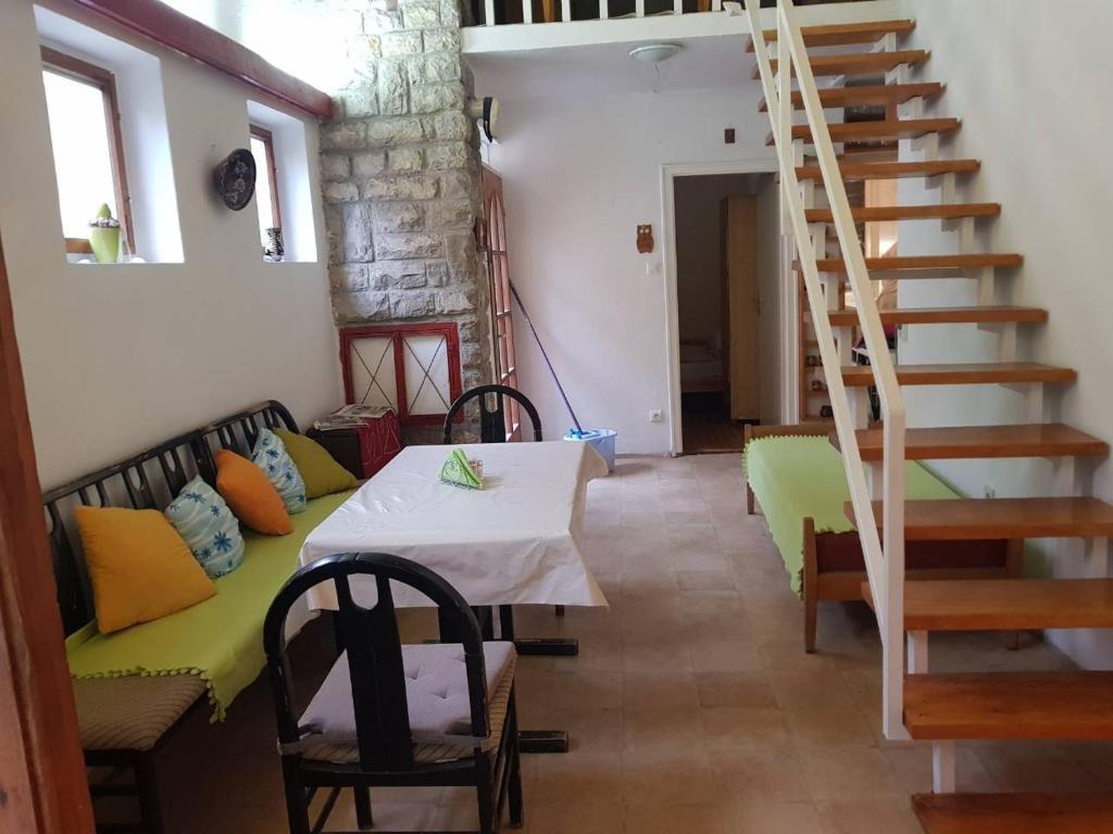 een woonkamer met een tafel en een trap bij Retro nyaralóház in Balatonkenese