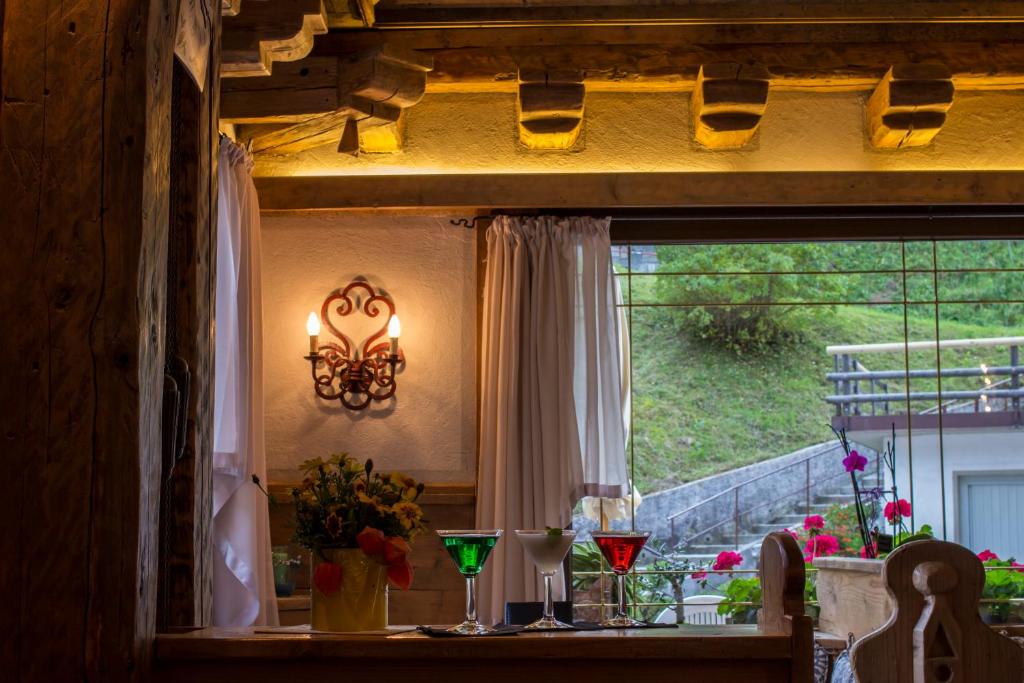 a dining room table with a window and a chandelier at Digonera Historic Hotel B&B in Rocca Pietore