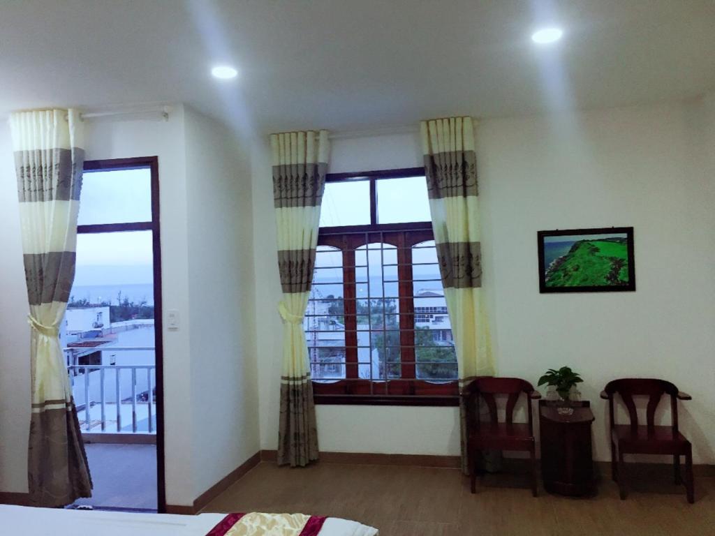 a bedroom with a bed and a large window at Yen Phu Hotel in Tuy Hoa