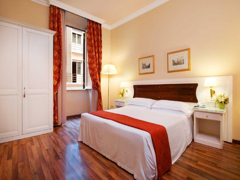 a bedroom with a large white bed and a window at Residenza Domiziano in Rome