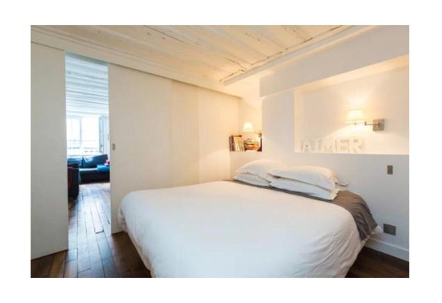 a hotel room with a white bed and white walls at Chez Vous ST HONORÉ in Paris
