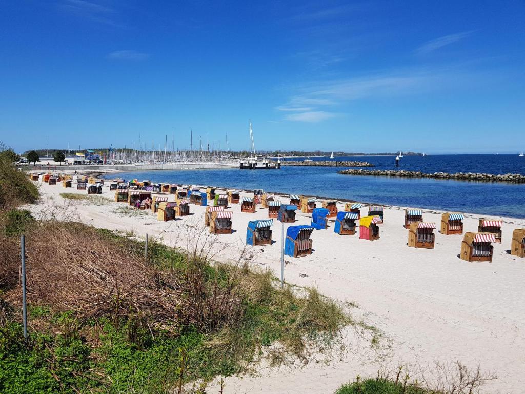 a group of chairs on a beach next to the water at Studiowohnung-Bernstein in Schilksee