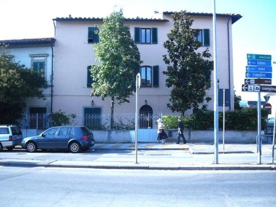 een blauwe auto geparkeerd voor een gebouw bij Magnolia Comfort & Rooms in Pisa