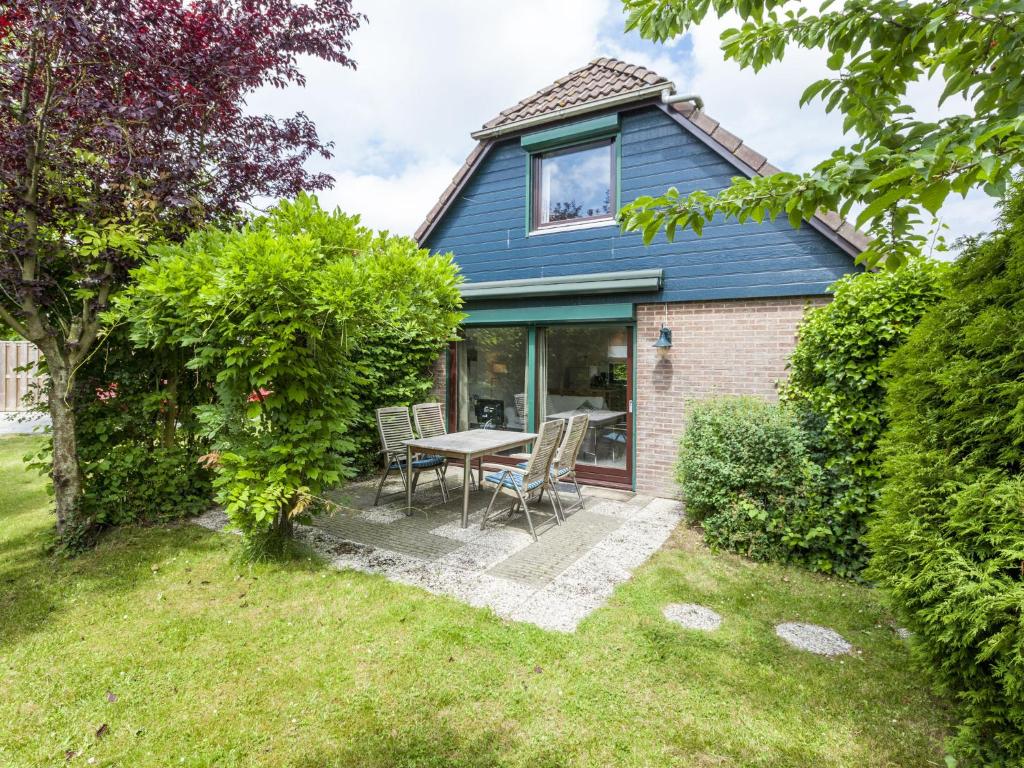 una casa con mesa y sillas en el patio en Lovely holiday home in Wolphaartsdijk en Wolphaartsdijk