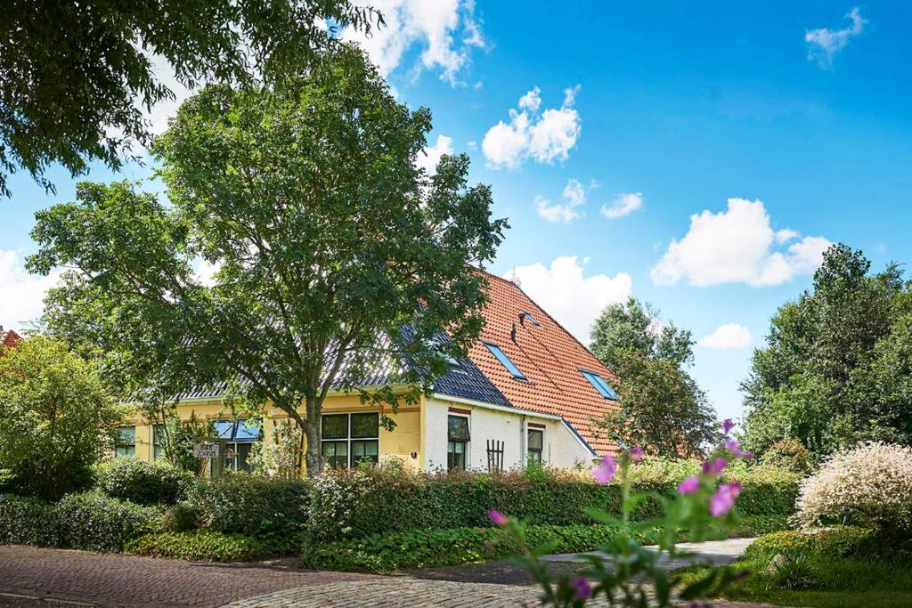 a yellow house with a red roof at Bed and Breakfast Joarum in Kubaard