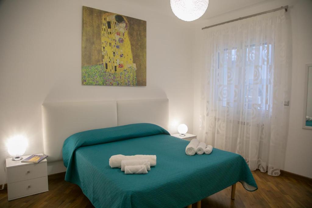 um quarto com uma cama verde com duas toalhas em Luna d'Arte em Mussomeli