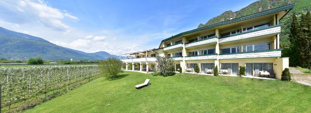 a building with a grass yard next to a vineyard at Hotel Greifenstein in Terlano