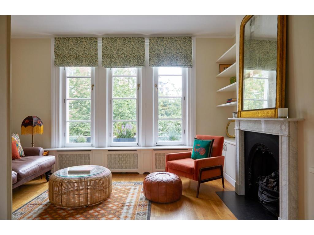a living room with a fireplace and two windows at Pass the Keys Charming Boho Flat with Terrace on Portobello Rd in London