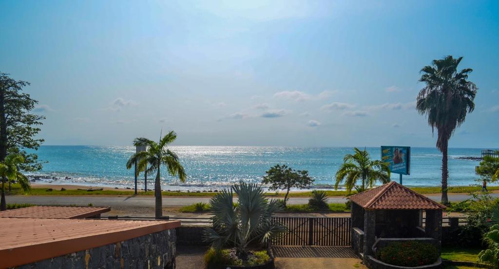 vistas a una playa con palmeras y al océano en Emoyeni Gardens en São Tomé