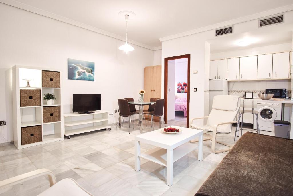 un soggiorno bianco con tavolo e cucina di Pureza Oasis Suite a Siviglia