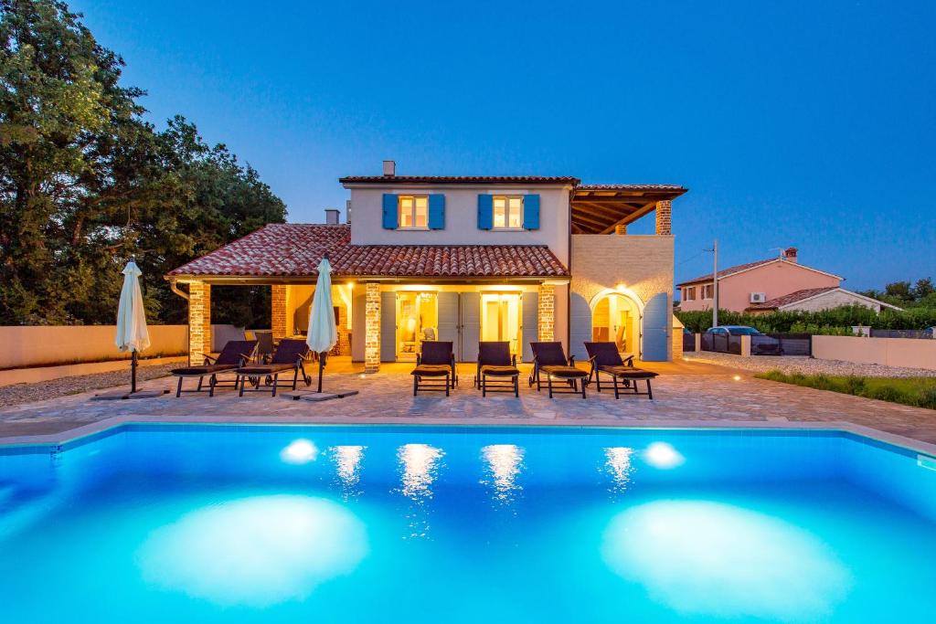 a villa with a swimming pool in front of a house at Villa Leticia in Hreljići