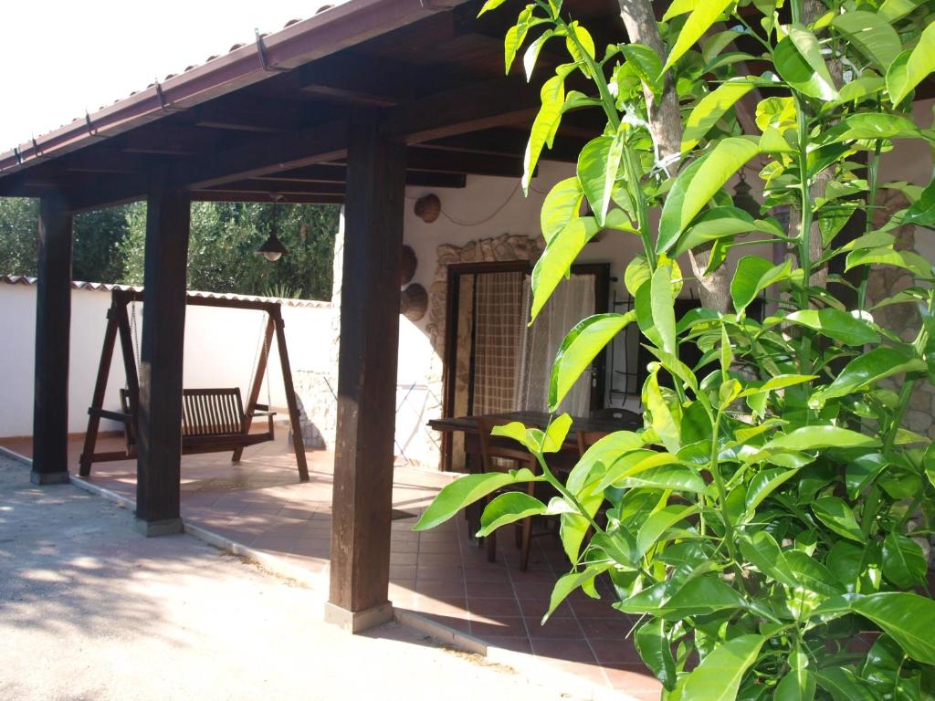 eine Veranda mit einer hölzernen Pergola und einer Bank in der Unterkunft Villa Fralù in Mattinata