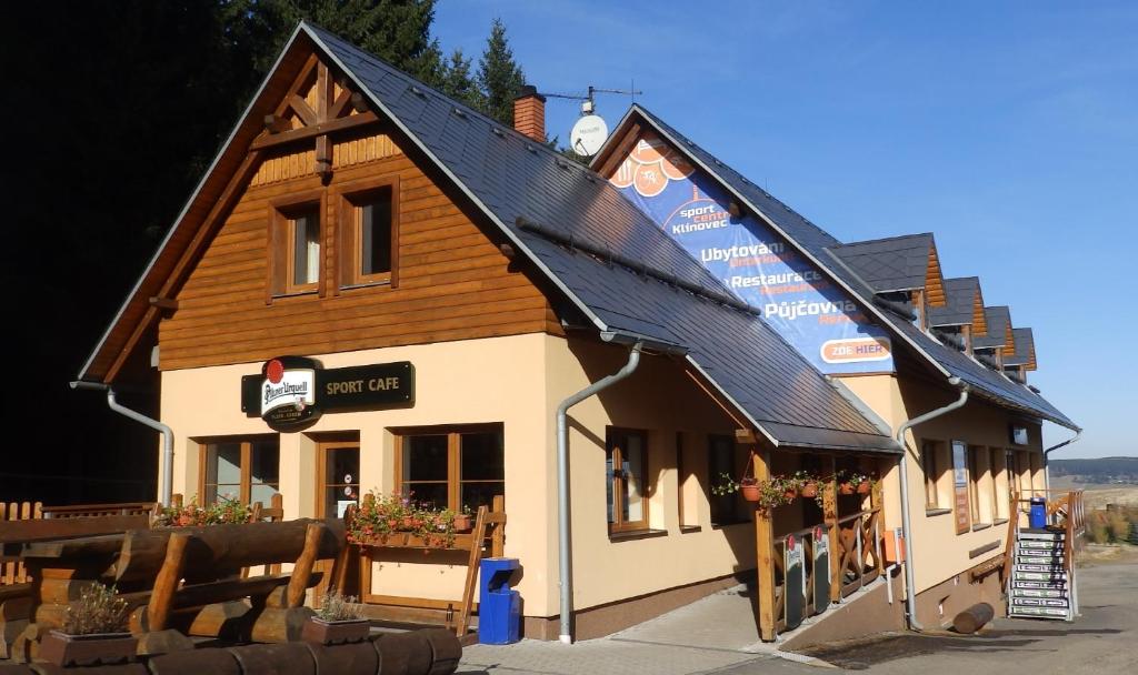 a building with a wooden roof with a sign on it at Sportcentrum Klínovec in Loučná pod Klínovcem