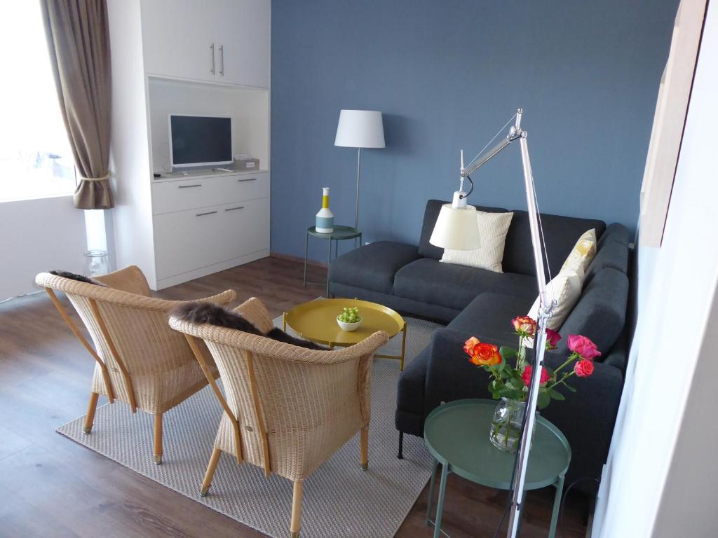 een woonkamer met een bank, stoelen en een tafel bij Leuchtturmblick in Wangerooge