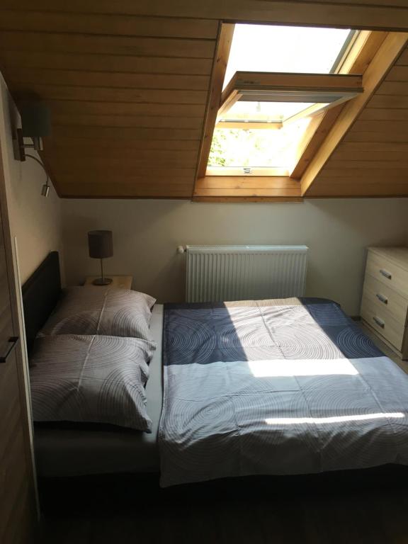 a bedroom with a bed and a skylight at Laza Vendégház in Zamárdi