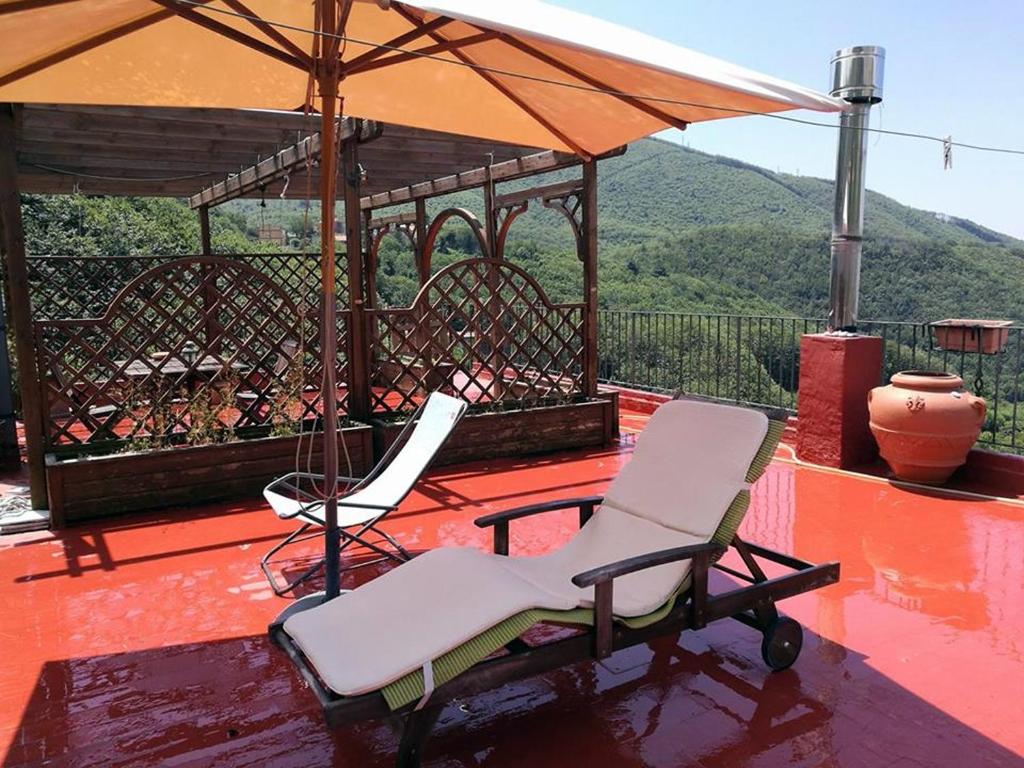 a pair of chairs and an umbrella on a deck at La Petite Maison - Panoramic Apartment di Terry De Martino in Vico Equense