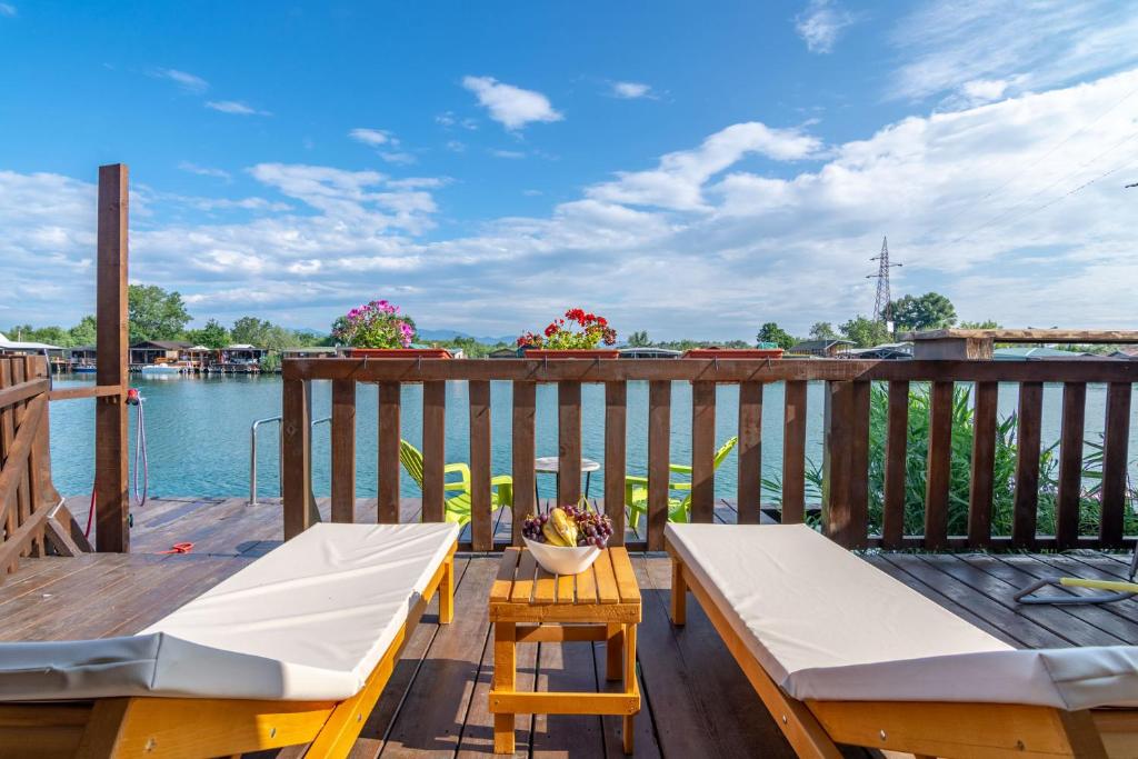 a deck with a table and chairs on the water at Hakuna Matata Apartments in Ulcinj