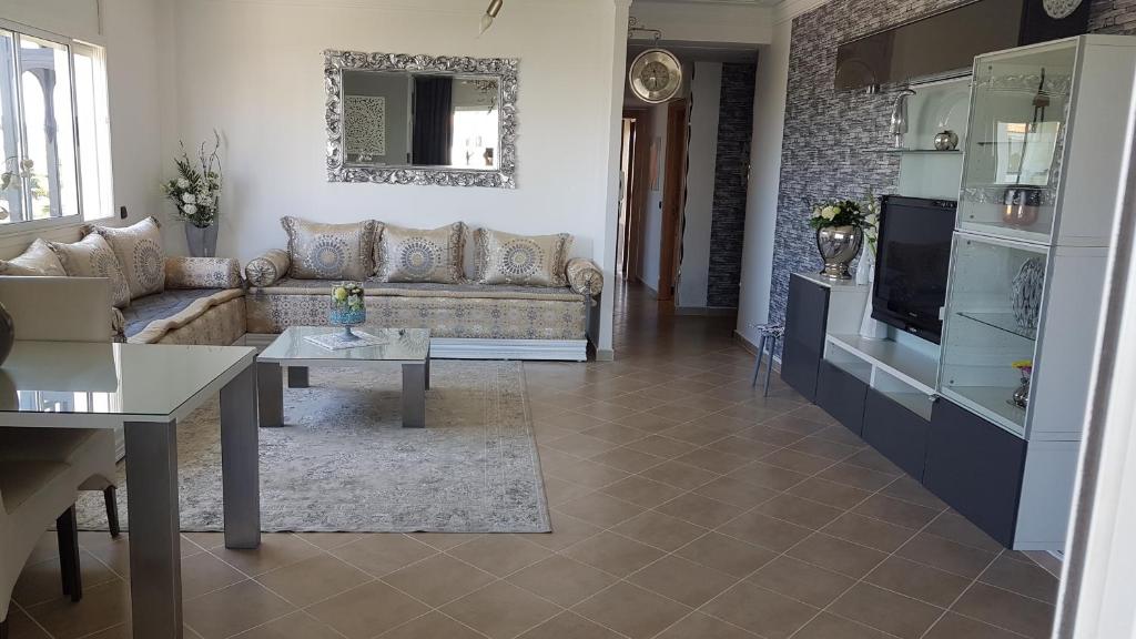 uma sala de estar com um sofá e uma mesa em Marina Golf, Tanger Emplacement supérieur Juste à côté de la piscine em Asilah