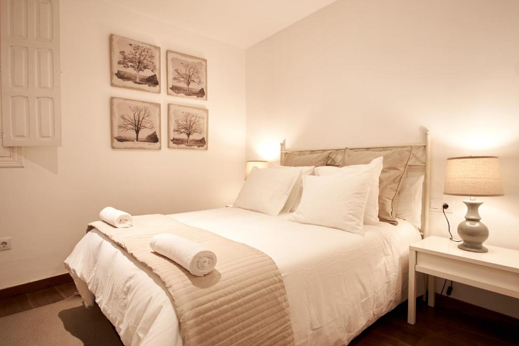 a bedroom with a white bed with towels on it at Tranquilo apartamento en zona monumental in Seville