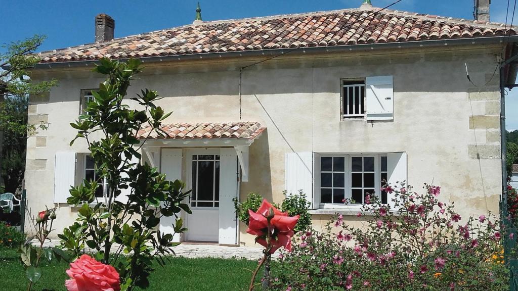 een wit huis met bloemen ervoor bij 12 Grand Sable in Saint-Émilion