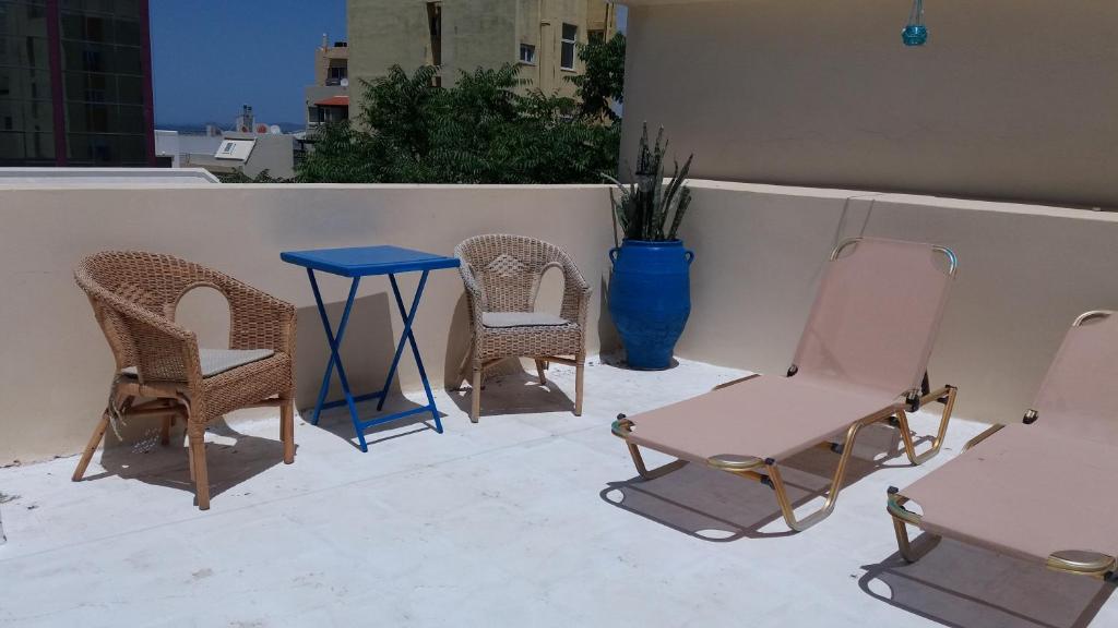 um grupo de cadeiras e uma mesa azul num pátio em Heraklion Youth Hostel em Iráclio