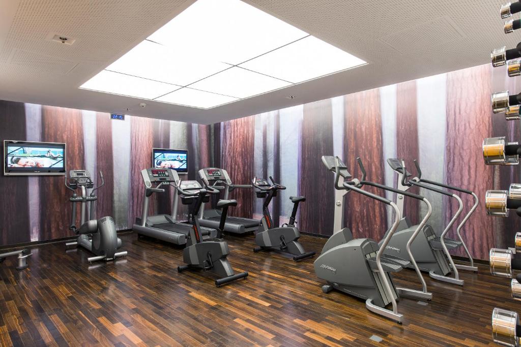 a gym with treadmills and exercise bikes in a room at Meliá Düsseldorf in Düsseldorf